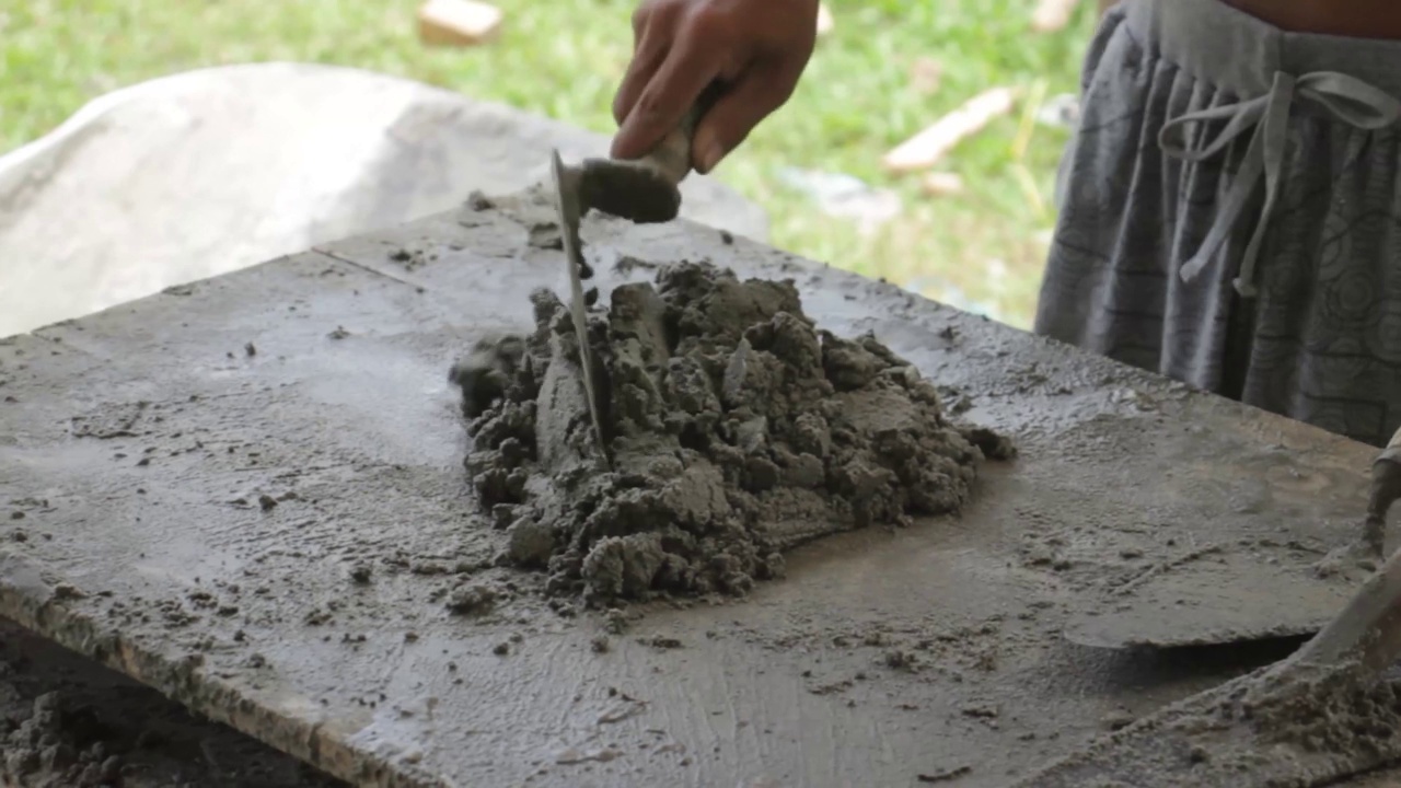 建筑工人用铲子搅拌水泥和沙子的手视频素材