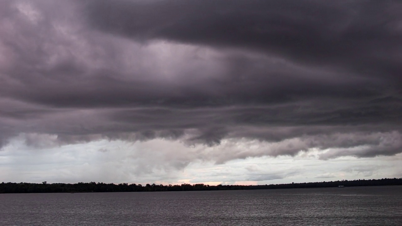 时间推移的黑暗戏剧性的暴风雨天空，快速移动的乌云在湖面上视频素材
