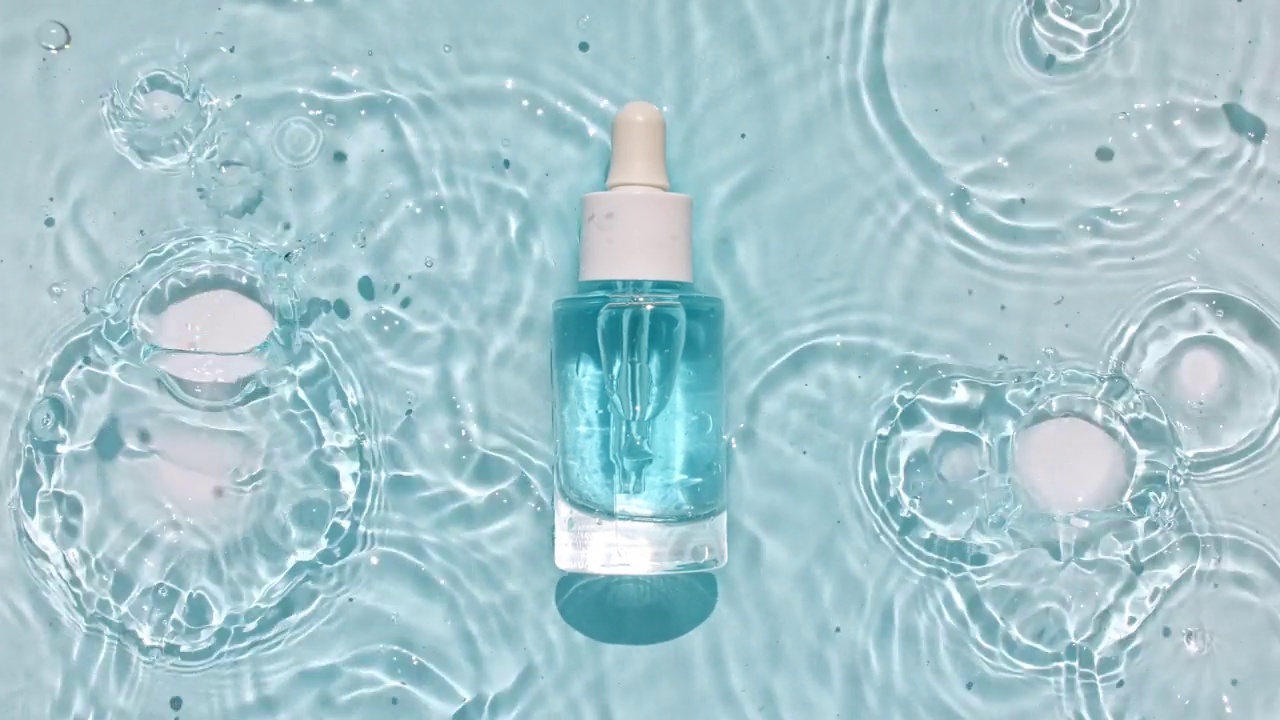 化妆品瓶，小瓶在水面上滴。纯净水，有阳光和阴影的反射。缓慢运动的波浪水。包装设计的视频，化妆品的广告视频下载