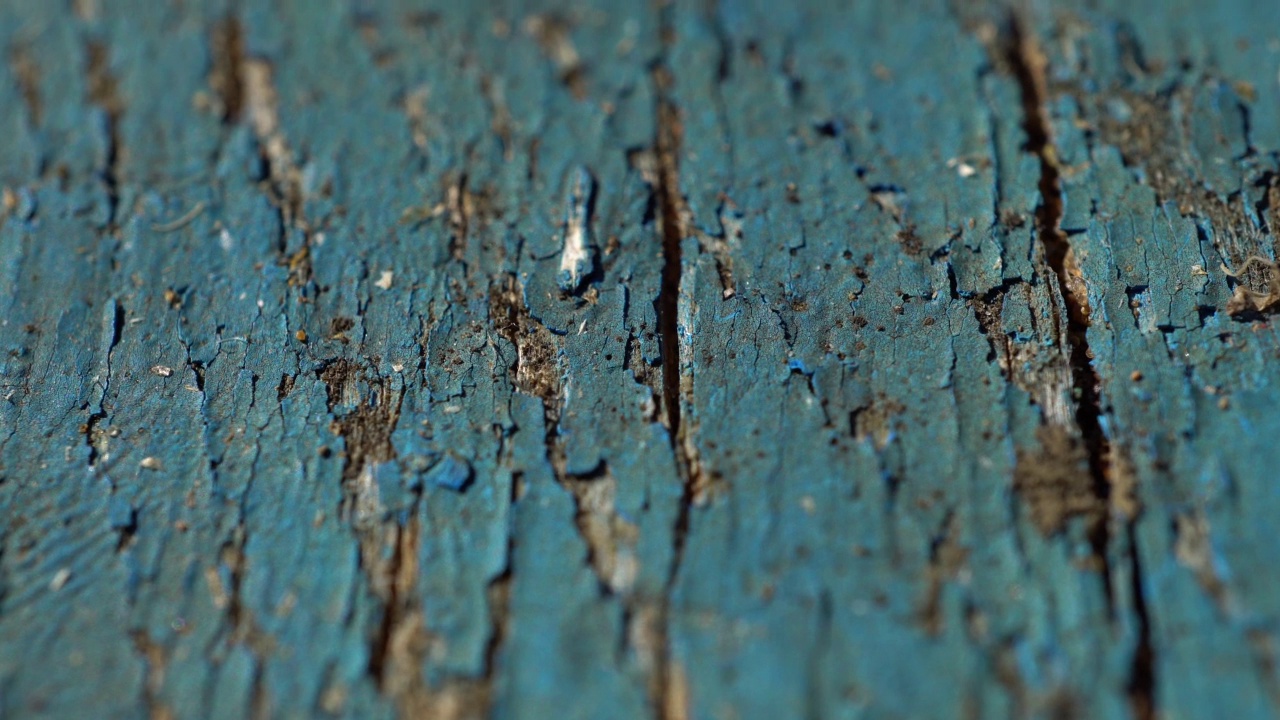 缓慢垂直滑动镜头的木墙与剥落的油漆。慢车的旧木板画，有质感。视频素材
