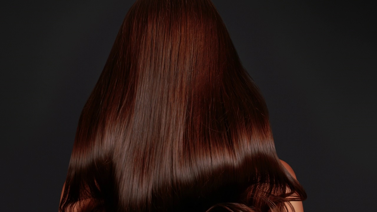 女人与直发亮的棕色头发下降剪出黑色背景视频素材