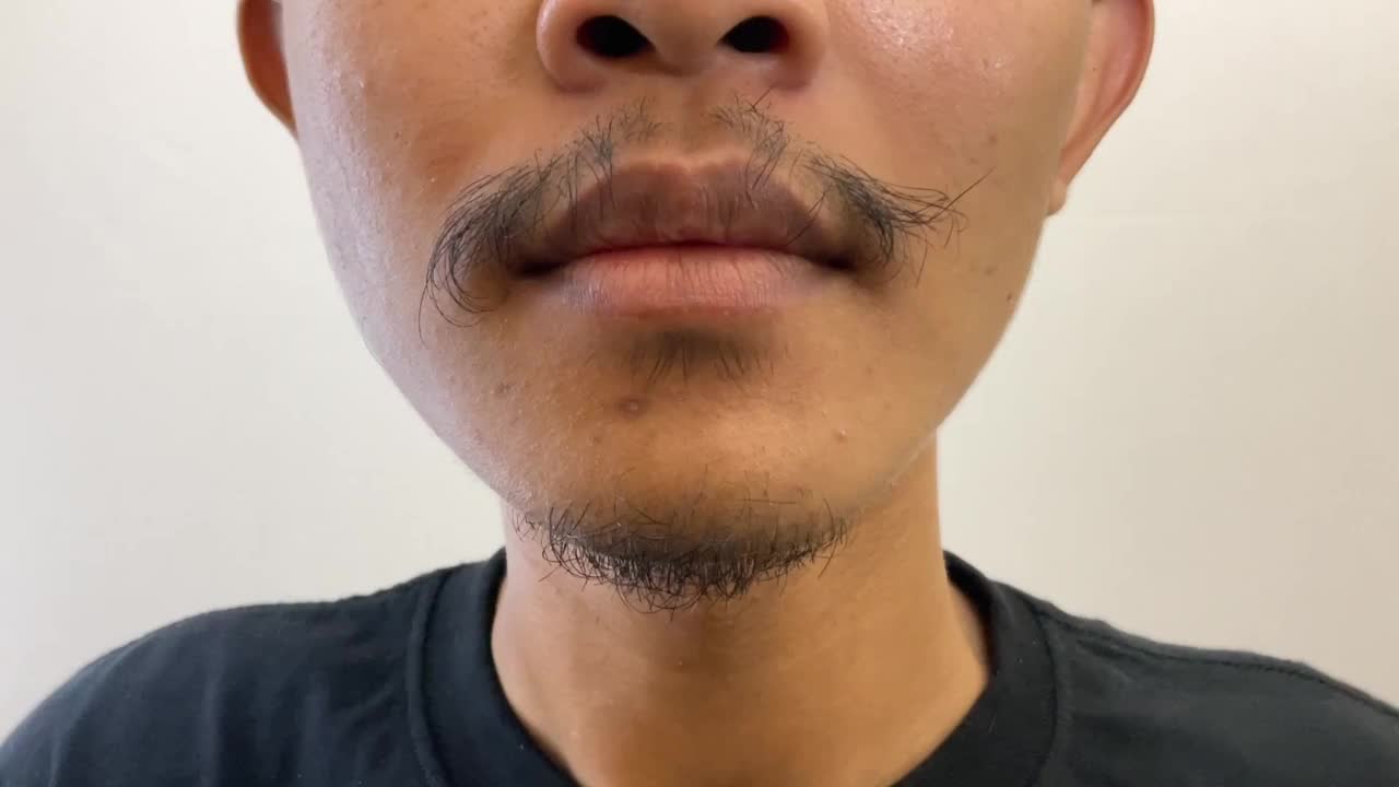 一个男人用电动剃须刀刮胡子。男性保健视频下载