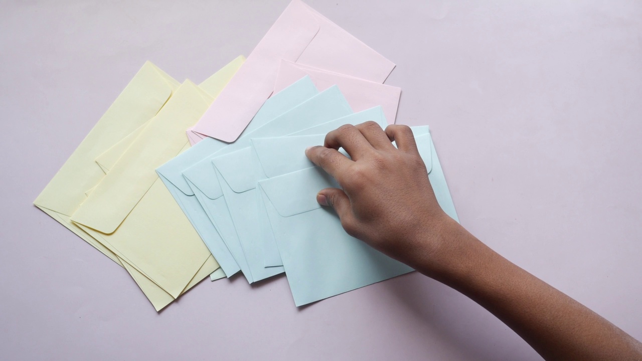 彩色信封上的粉红色背景与复制空间。视频下载