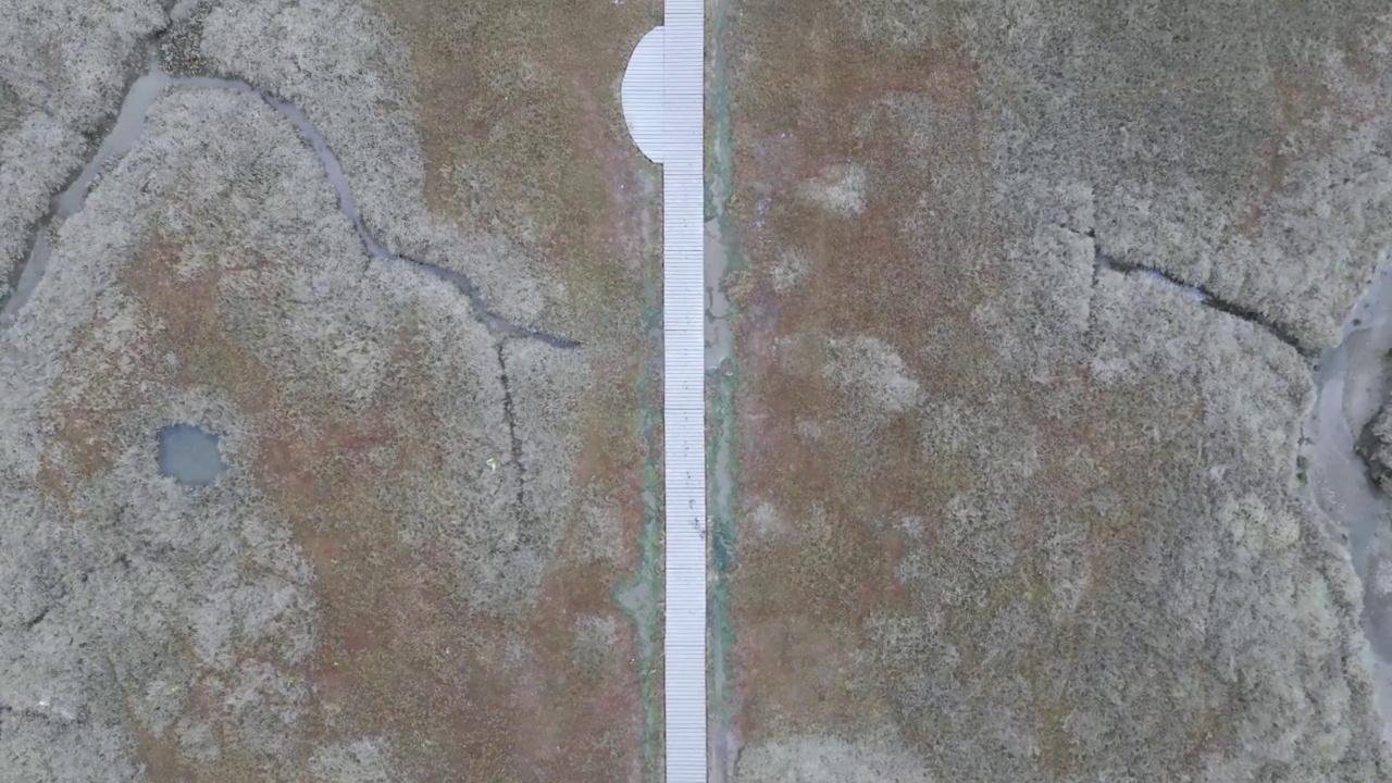 航拍画面显示，默西岛一条长长的道路上行驶着车辆，海上有一艘船视频下载