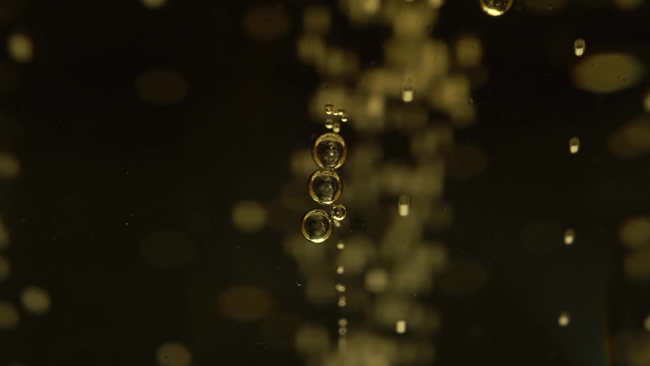 一杯香槟的宏观视图。二氧化碳的气泡漂浮起来，形成一个美丽的抽象背景。视频下载