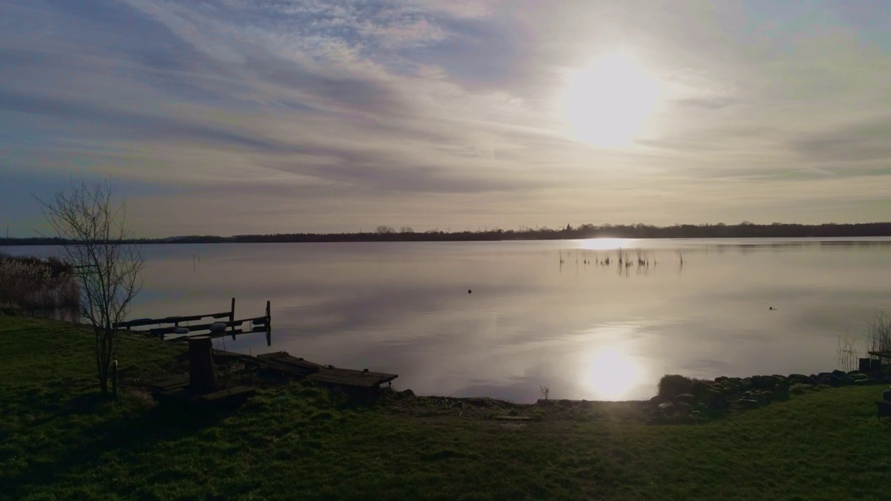 在4K中日出时平静湖水的美丽岸边景观视频下载