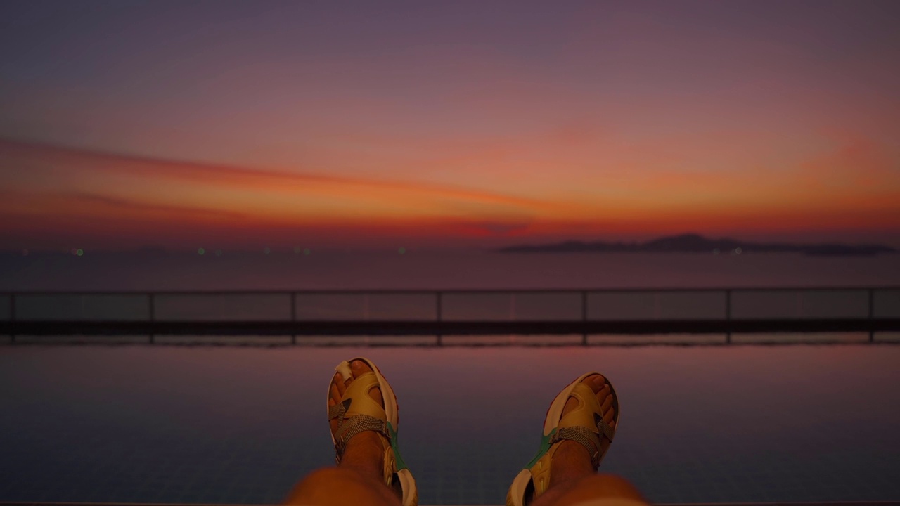 屋顶游泳池里的腿特写，日落时分视频下载