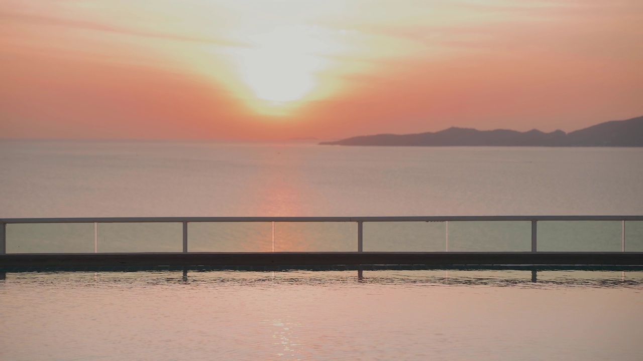 美丽的日落在海上，从游泳池游泳视频下载