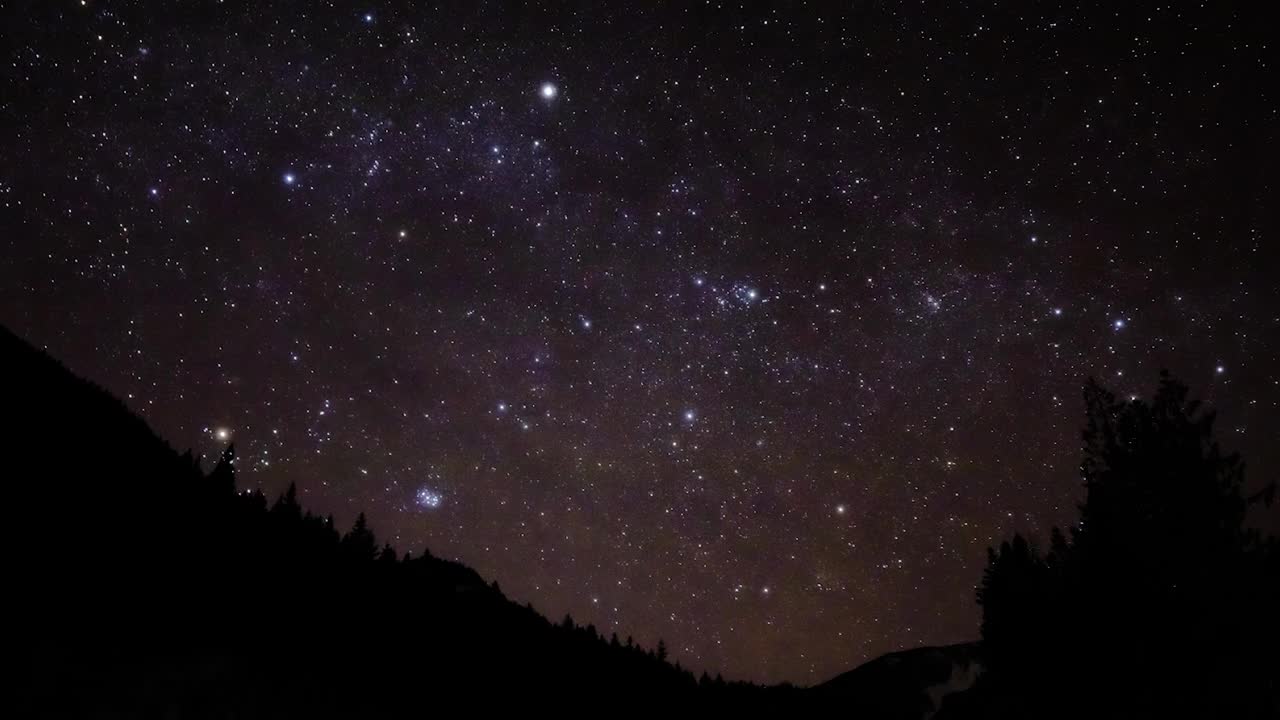 美丽的时间推移场景的远景与星空剪影山在森林视频下载