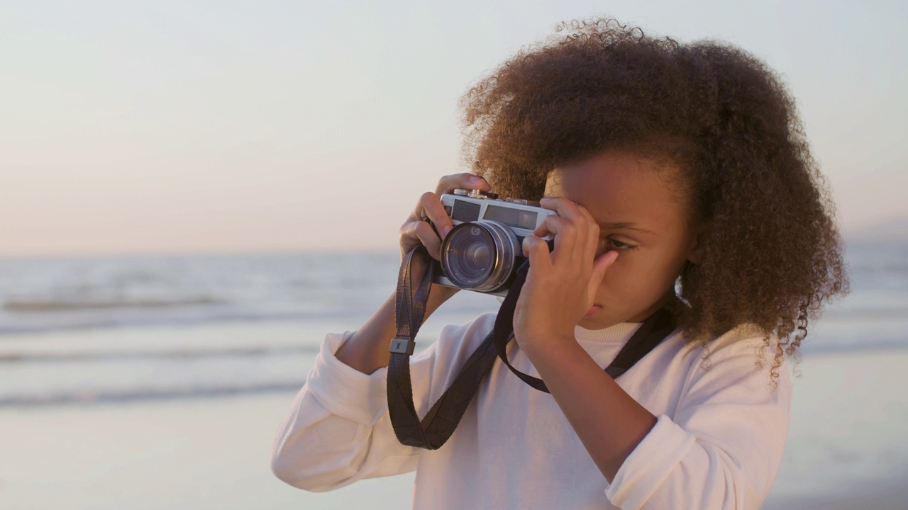 可爱的黑人女孩花时间在海滨，拍照。视频下载