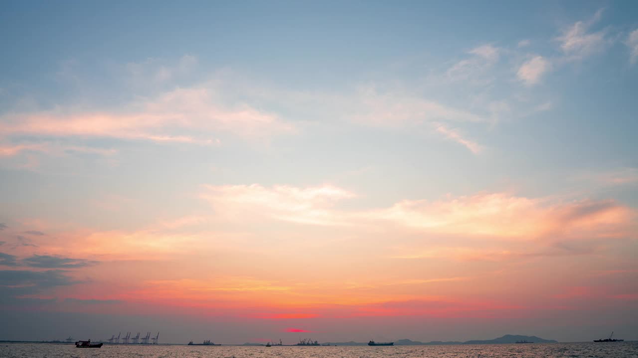 日落时间间隔4k彩色日落在海上。浪漫的日落，蓝色和橙色的云在天空流动。壮丽的夏日风光。视频素材