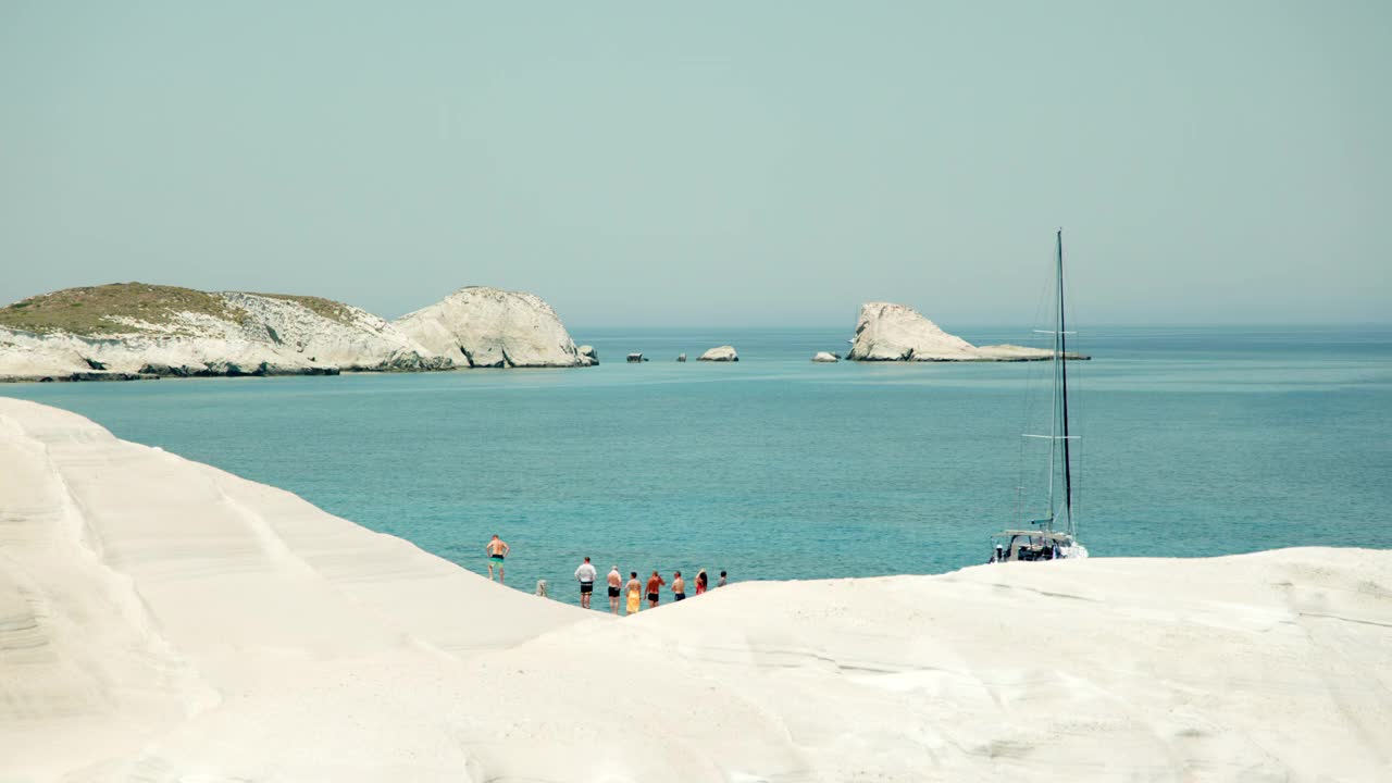 游客们在希腊米洛斯岛的Sarakiniko海滩欣赏美景视频下载