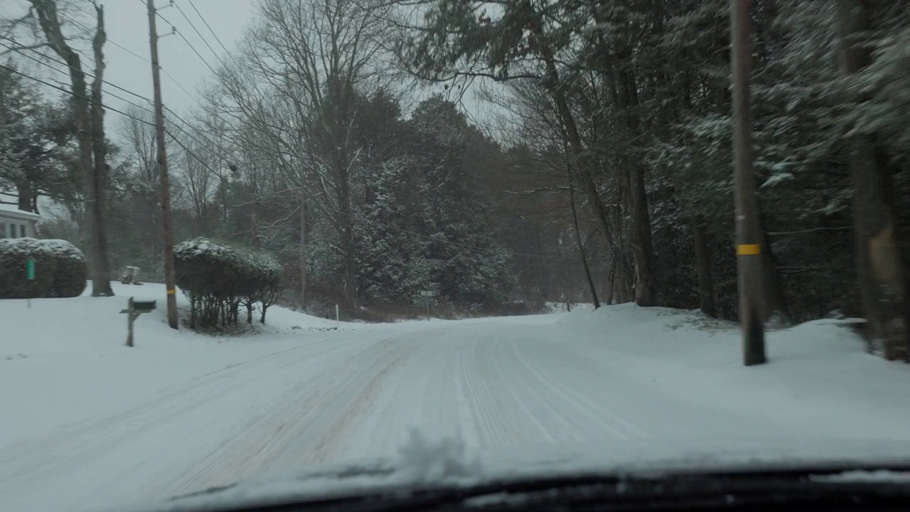 在冬天的大雪中，沿着宾夕法尼亚州波科诺的森林开车。视频素材