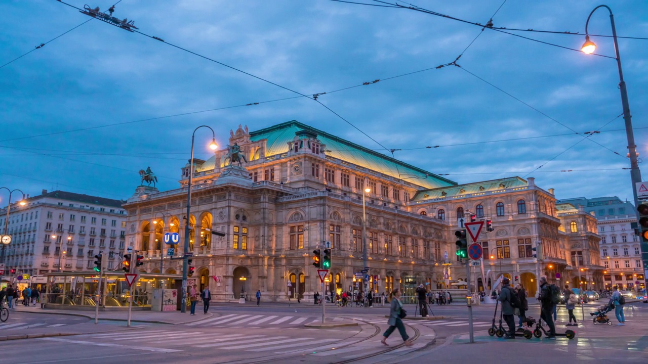 奥地利维也纳，维也纳国家歌剧院前的交通道路和人们行走的时间推移日落场景视频下载