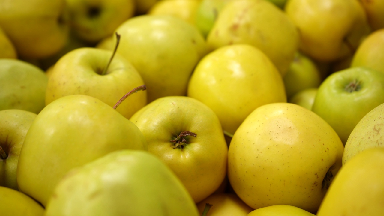 商店货架上新鲜多汁可口的黄苹果。视频素材