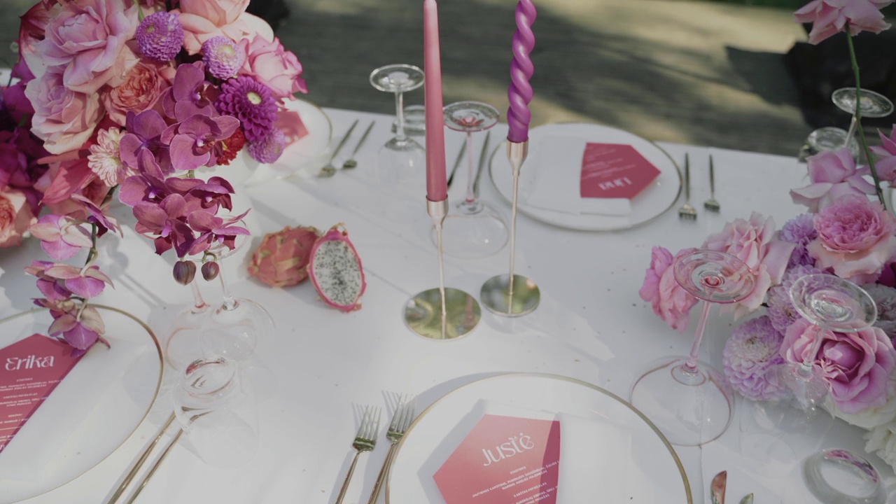 婚礼桌上装饰着粉红色的鲜花和蜡烛的特写视频下载