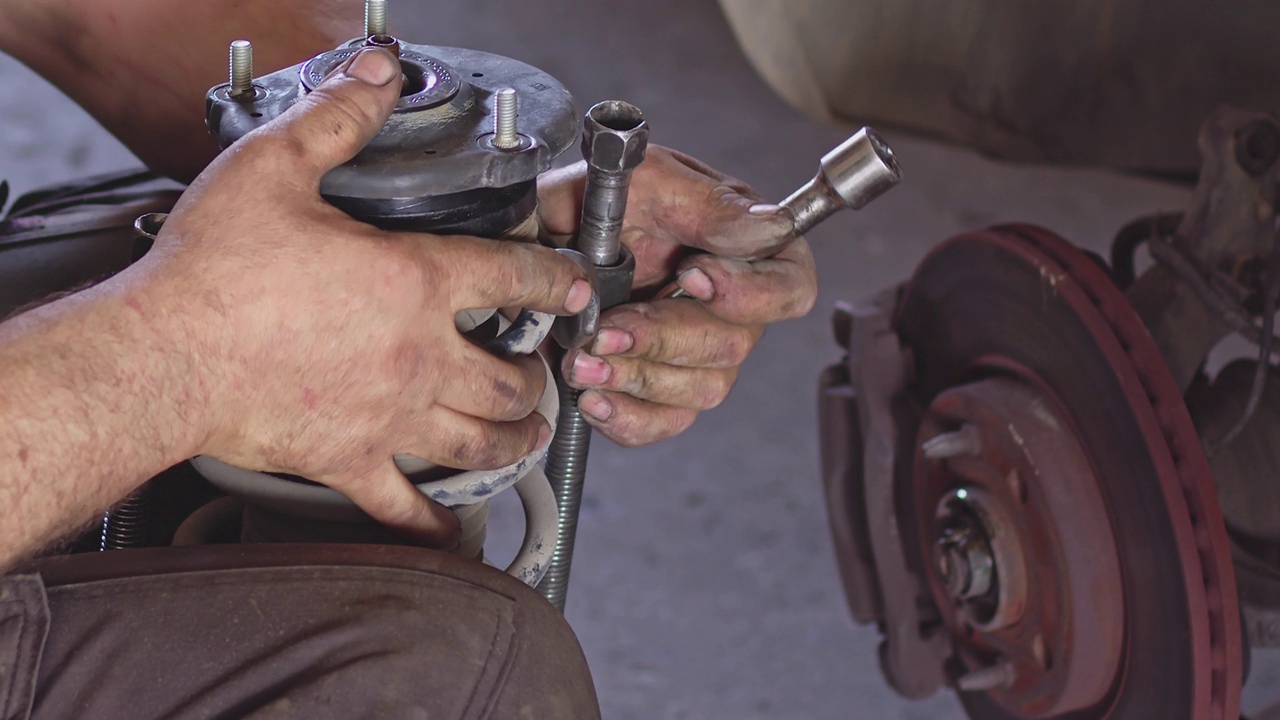 汽车修理工更换汽车减震器视频素材
