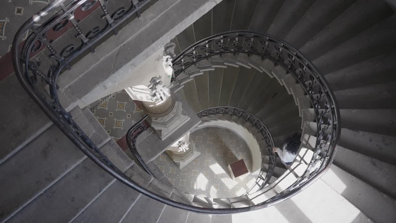 女人走下螺旋楼梯，慢动作视频素材
