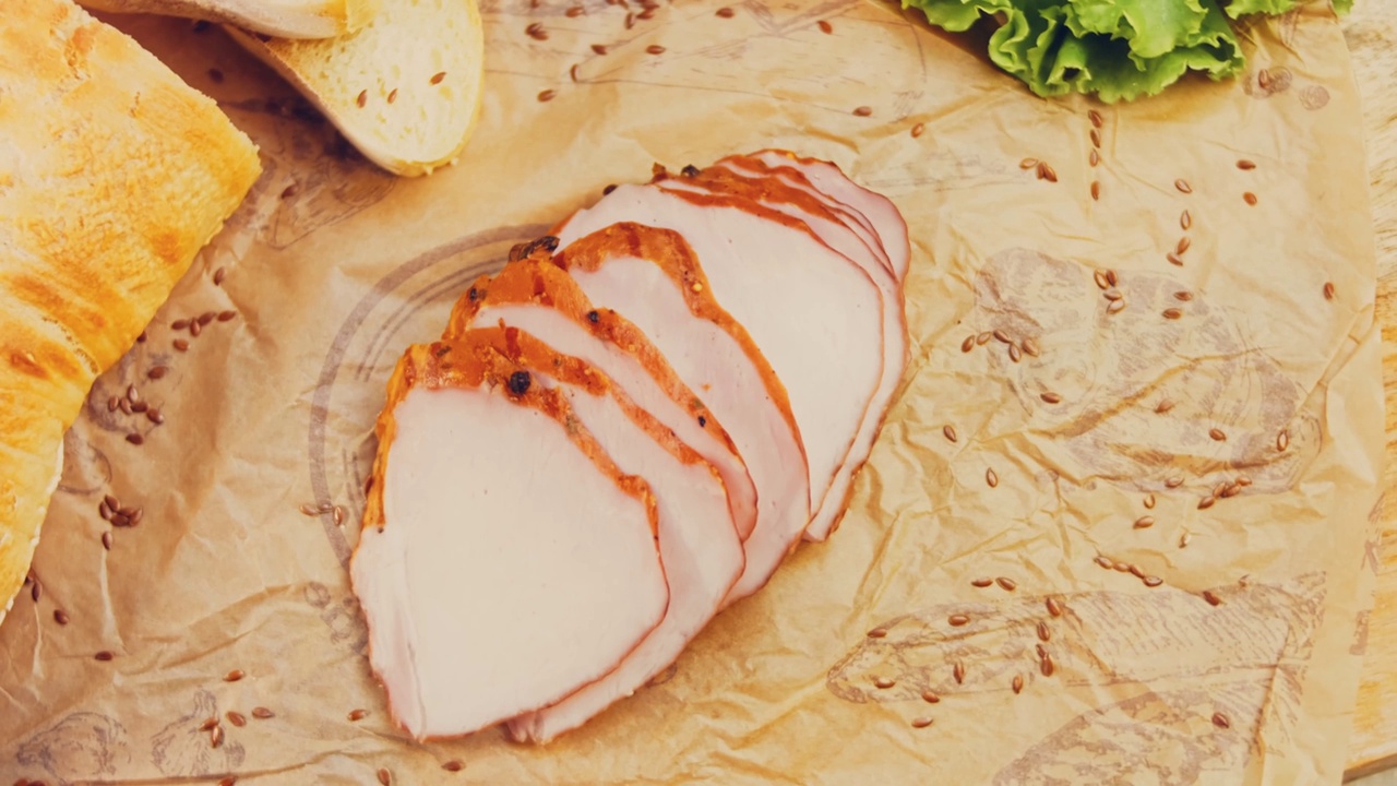 猪肉里脊与法国法棍切片的波浪效果。香肠放在复古风格的烹饪托盘上，放在食物纸上。在滑块上进行慢动作拍摄。我们也用新鲜的生菜叶视频下载