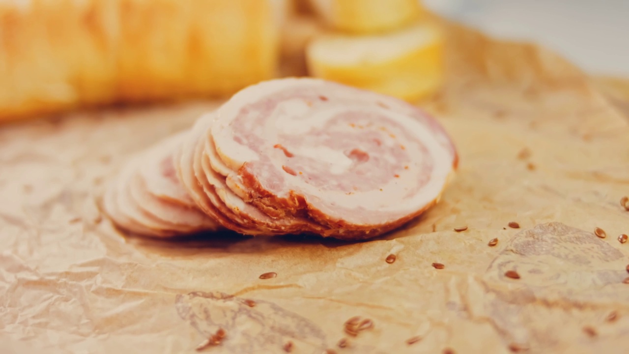 波状效果的猪肉香肠卷切片与法国法棍。香肠放在复古风格的烹饪托盘上，放在食物纸上。在滑块上进行慢动作拍摄。我们也用新鲜的生菜叶视频下载