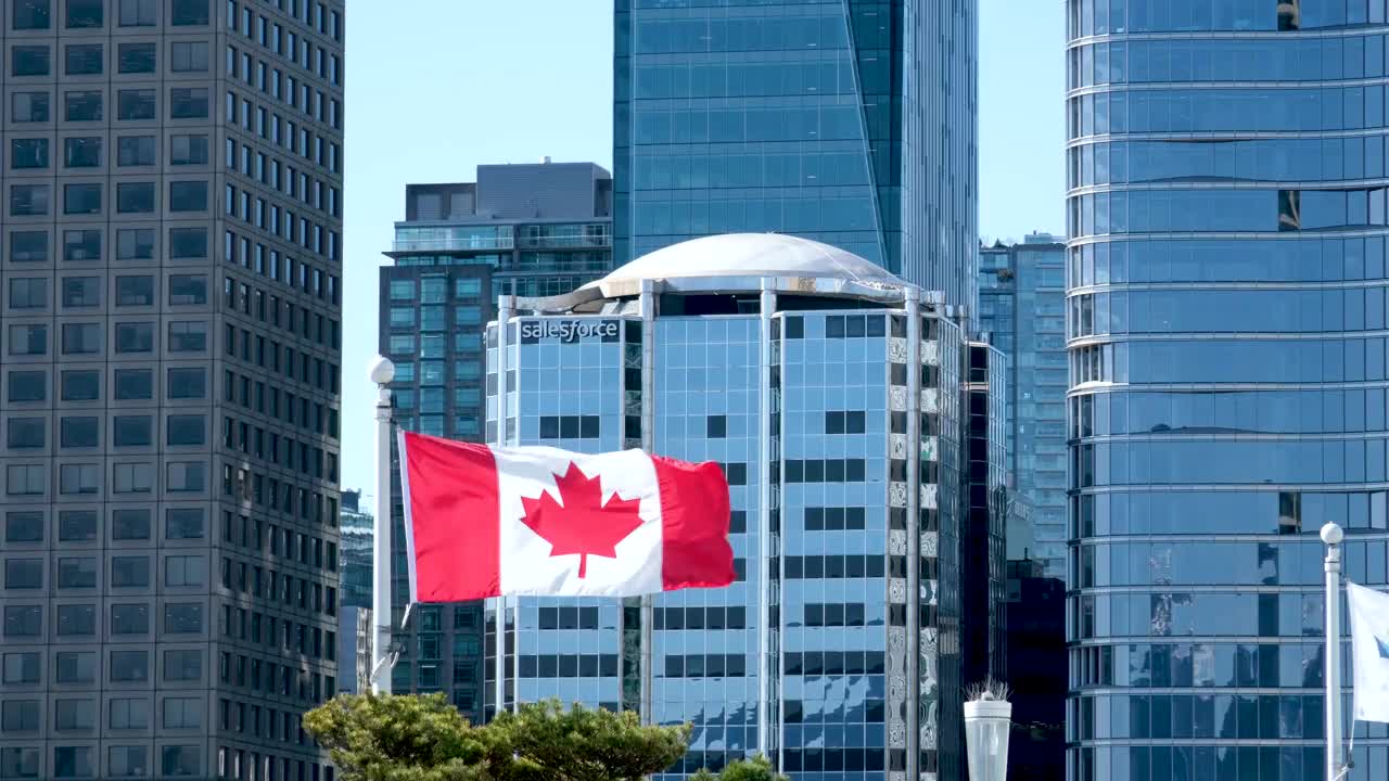 加拿大国旗在温哥华观景台和海港中心的旋转餐厅顶上飘扬，俯瞰加拿大的温哥华港。无人机拍摄的视频下载