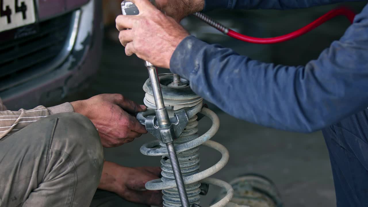 机械师在修理店修理汽车减震器视频下载