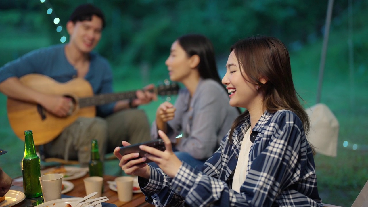 4K一群亚洲人朋友在暑假一起露营时用手机自拍视频下载