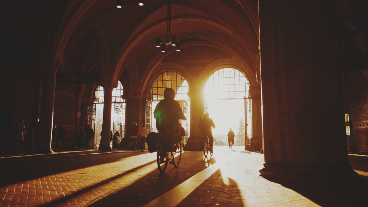 人们在通往牌坊的街道上骑自行车。人们在国立博物馆下面的隧道里骑自行车视频素材