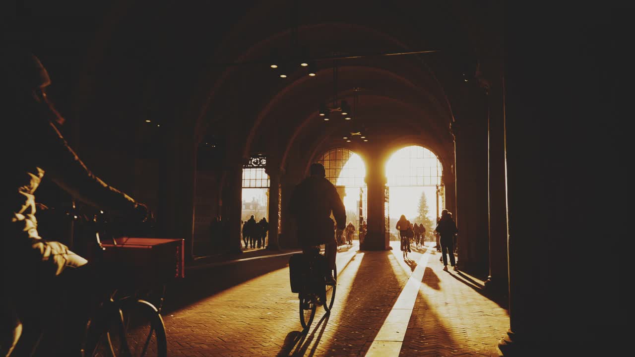 人们在通往入口的自行车道上骑自行车。人们在通往阿姆斯特丹国立博物馆拱门入口的自行车道上骑自行车视频素材