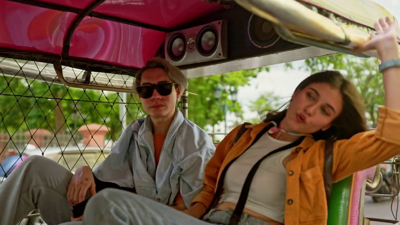 年轻夫妇在曼谷第一次骑嘟嘟车时兴奋不已。视频素材