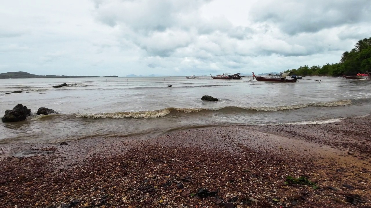 传统的长尾船勇敢地面对安达曼海即将来临的风暴视频素材