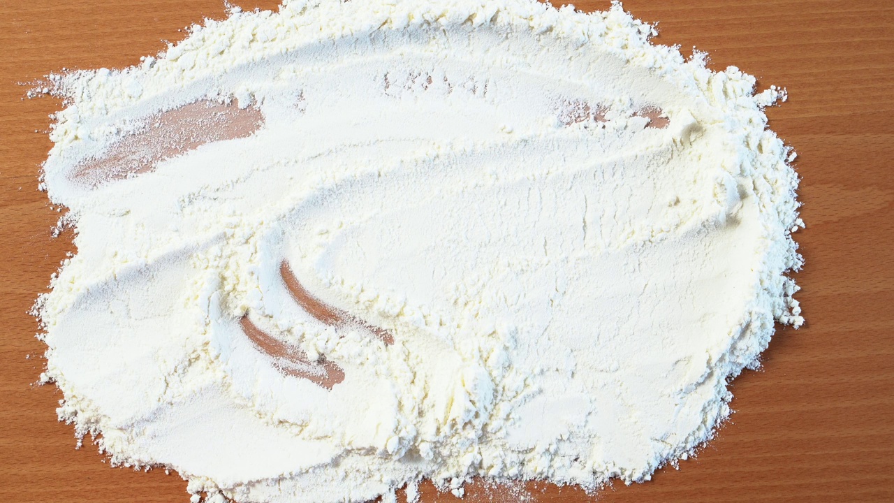 手倒白筛面粉在桌子水平，烹饪自制烘焙，面包视频素材