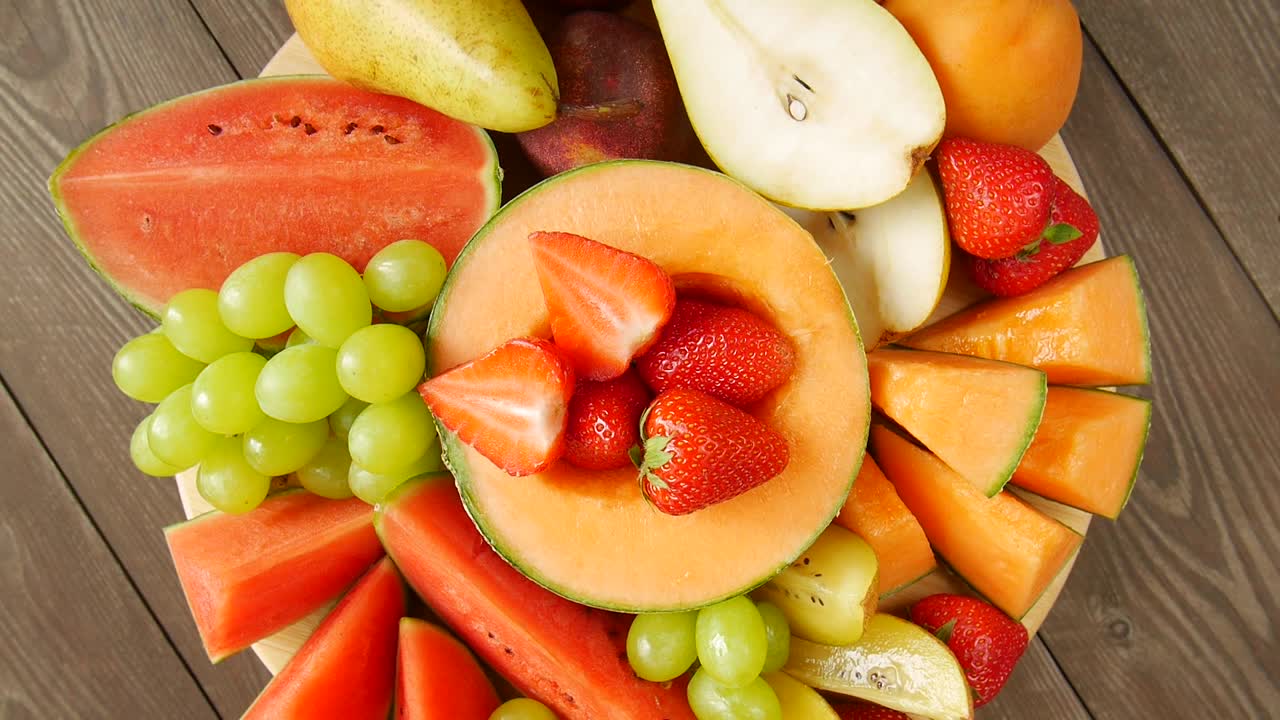 水果和浆果放在盘子里。视频下载