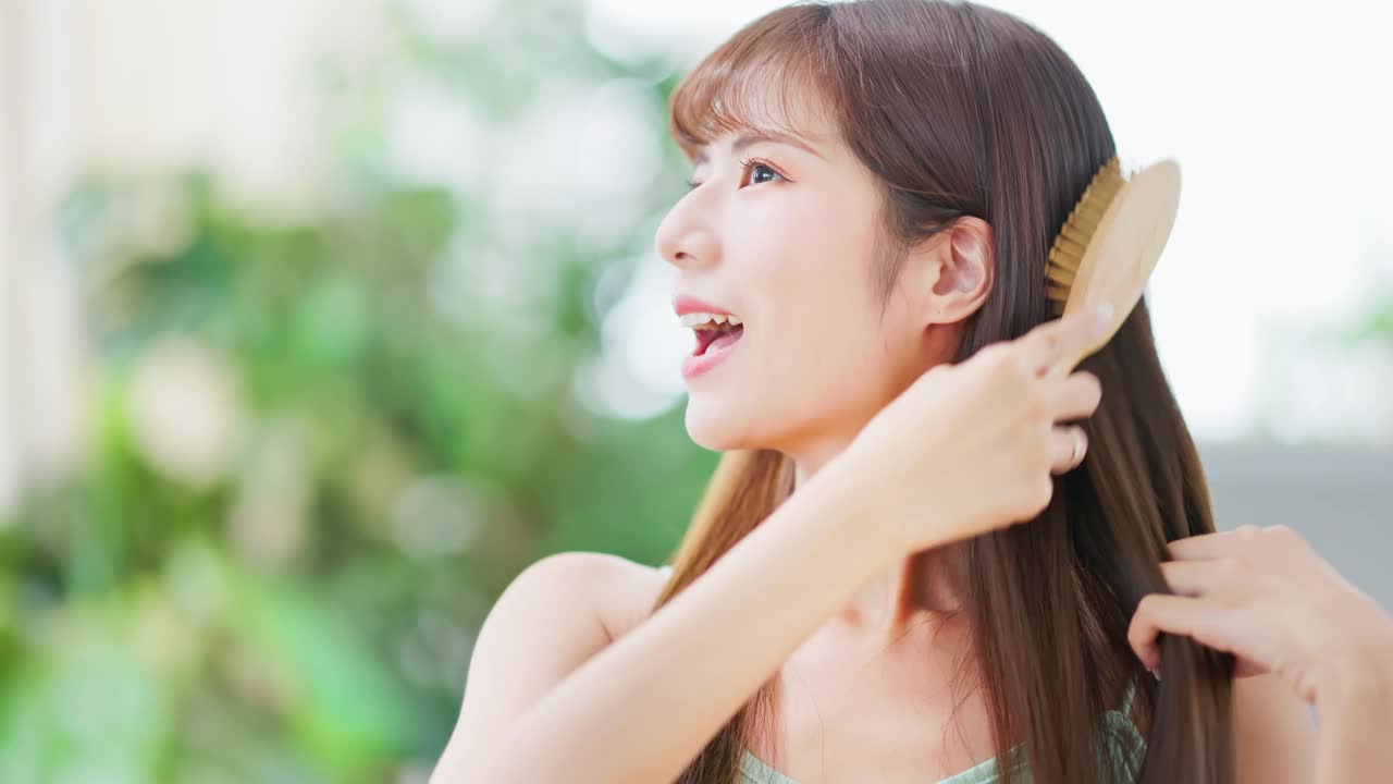 亚洲快乐女人梳头发视频素材