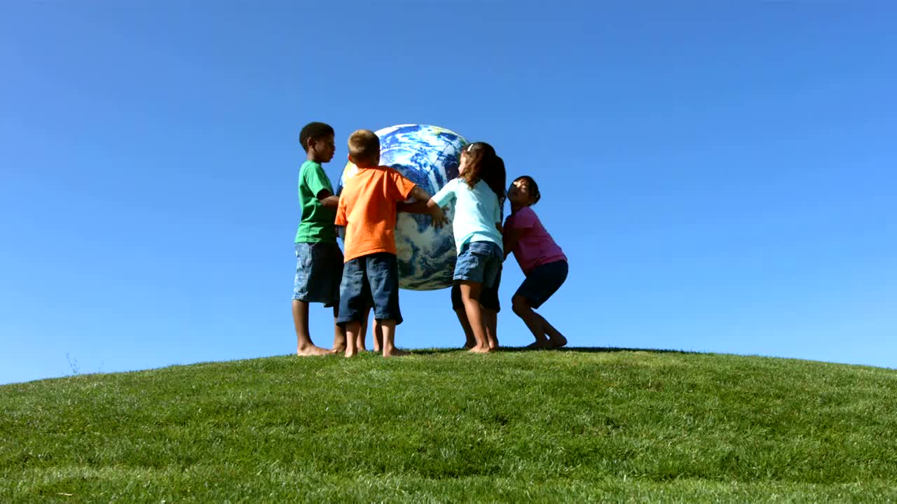 一群孩子玩着大地球球，慢动作视频下载