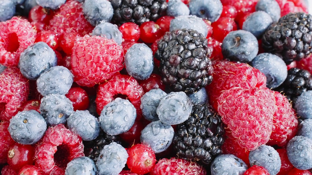 图案:新鲜的覆盆子，黑莓，蓝莓，红醋栗旋转上视图。健康的水果浆果。新鲜水果小吃。维生素k夏季概念视频下载