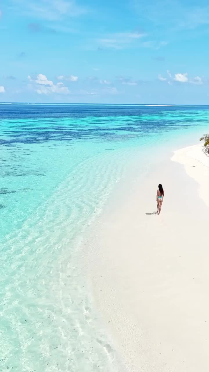 鸟瞰图，一个女人走在令人难以置信的海滩上视频下载