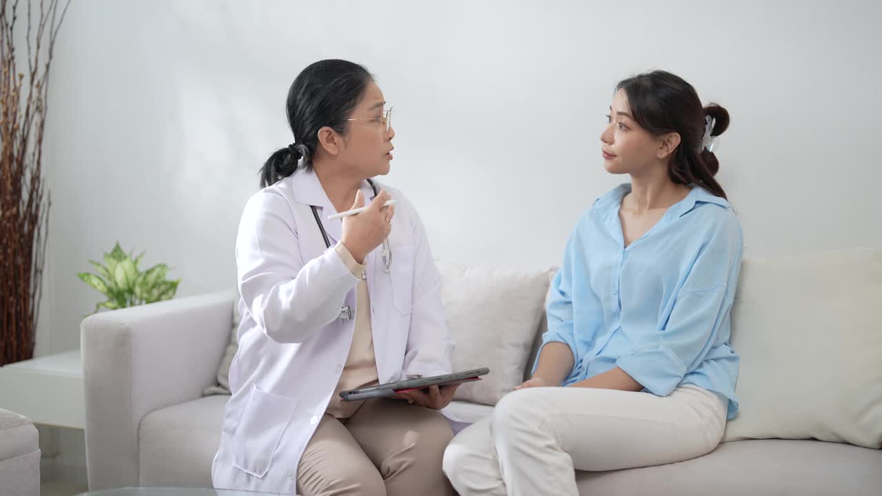 亚洲医生检查美丽病人的喉咙，检查症状、保健和医疗观念。视频下载