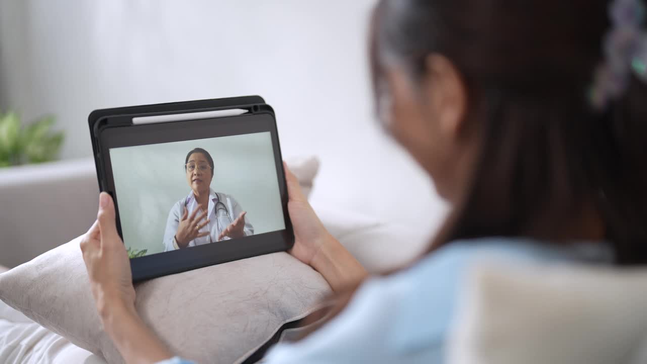 病人在家里的客厅里通过视频电话与医生交谈。视频下载