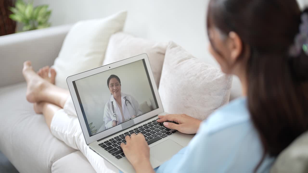 病人在家里的客厅里通过视频电话与医生交谈。视频下载
