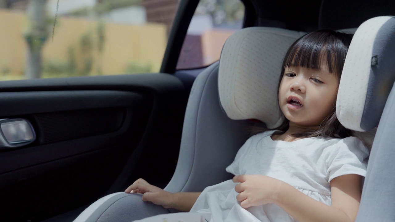 在一次家庭旅行中，一个可爱的女孩坐在汽车后座上欣赏。视频下载