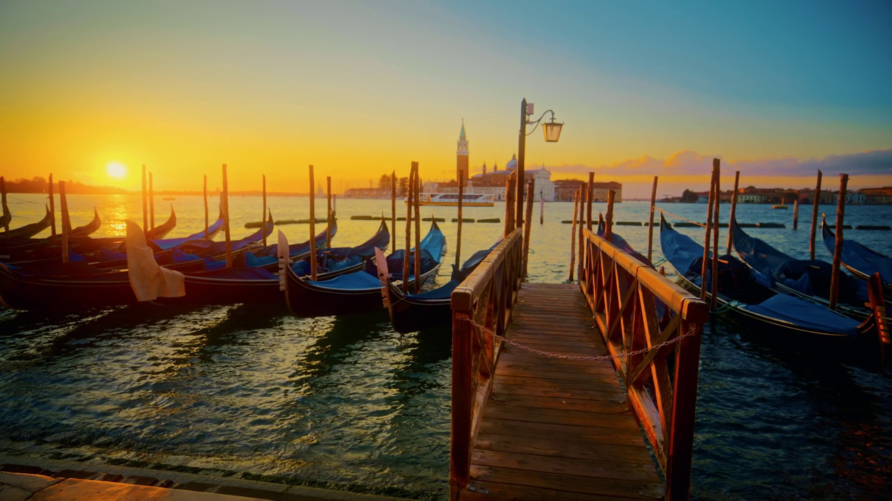 日出时威尼斯的速度坡道/时间扭曲贡多拉，背景是圣乔治马焦雷岛。威尼斯，日出时的贡多拉船。意大利视频下载