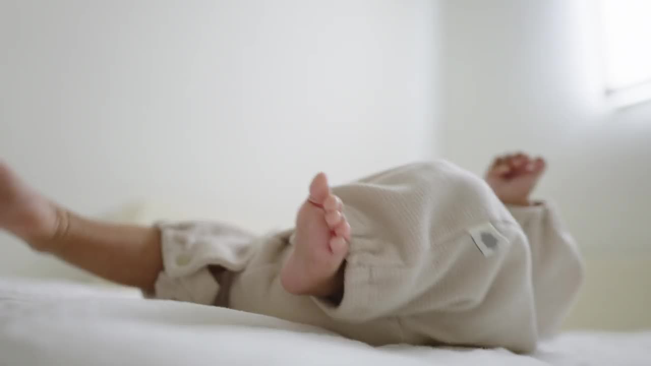 刚出生的婴儿在婴儿床里哭时，腿使劲扭动。视频下载