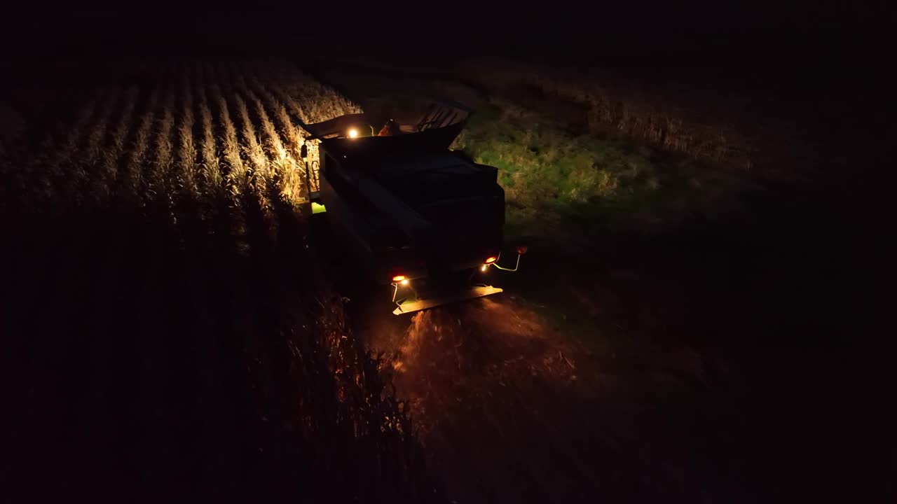 夜间联合收割机收割玉米的航拍照片。美国农民工作到天黑。视频下载