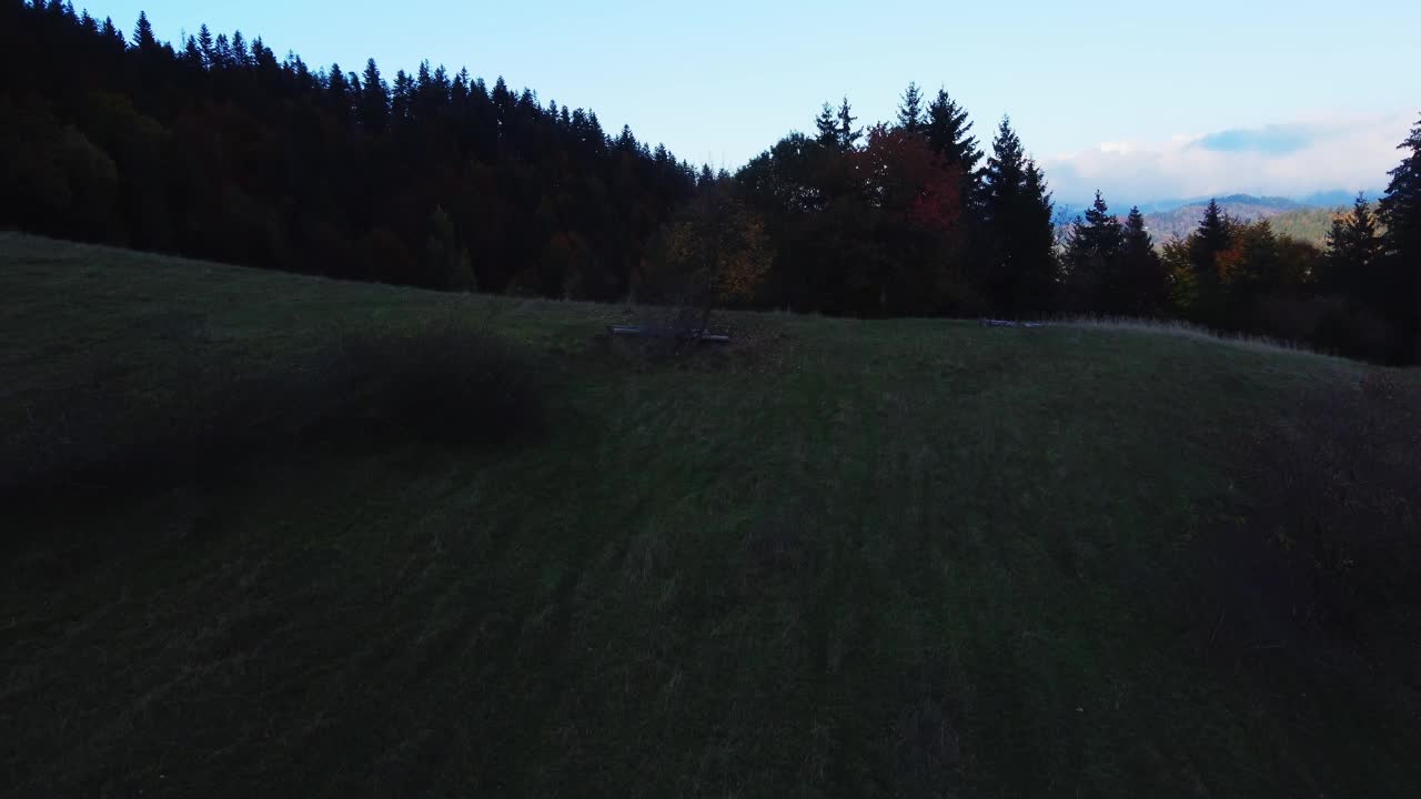 鸟瞰乡村森林丘陵景观。秋天小山间山谷中的山村视频下载