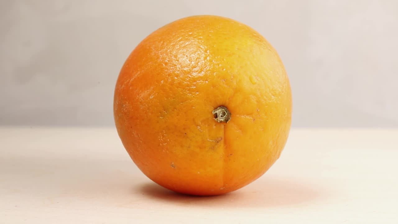 一种成熟的、多汁的、开胃的橙色水果可以用刀割伤人的手。视频下载