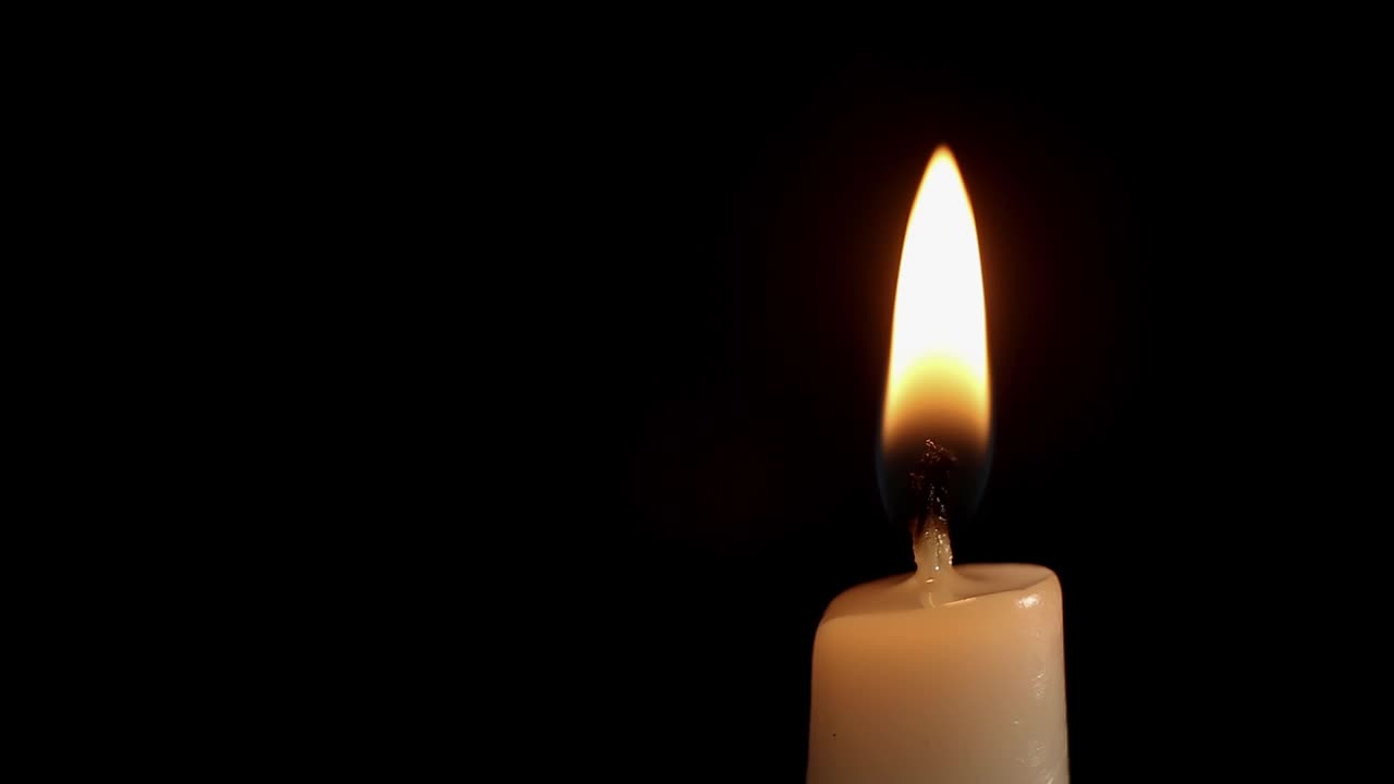 蜡烛在黑暗中燃烧，背景是黑色的视频下载