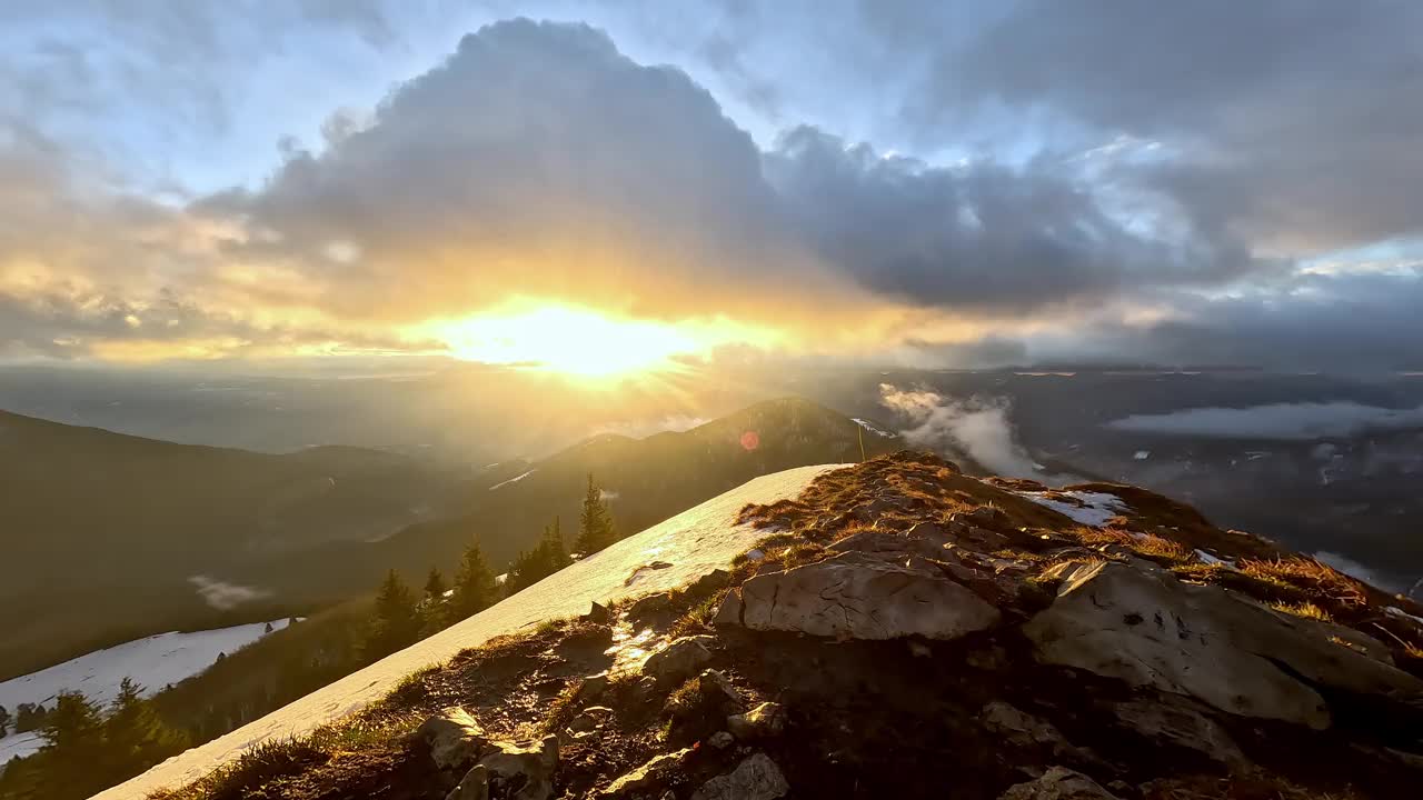 冬天风大的山景，山岭上覆盖着雪和草，云浓，夕阳西下，视频下载