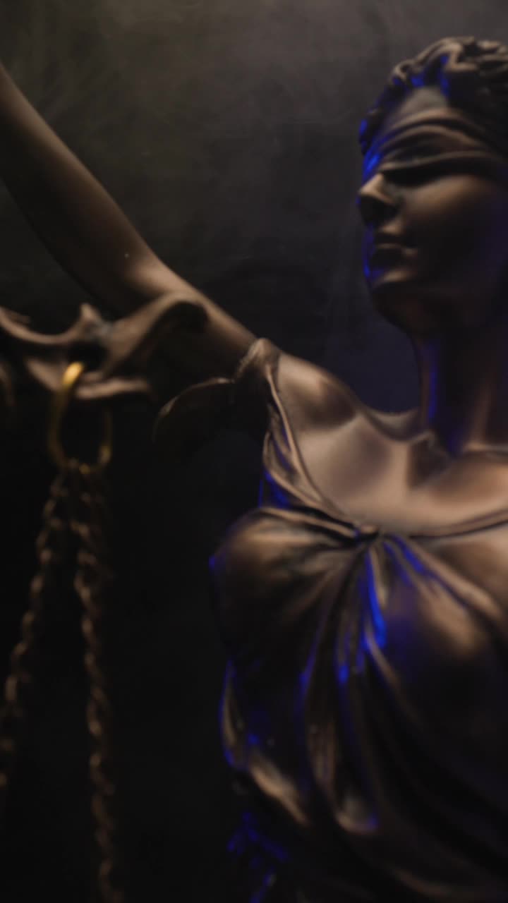 垂直视频中，青铜雕像法拿着天平，说明了平等和平衡的概念，黑色背景上的警灯和烟雾视频下载