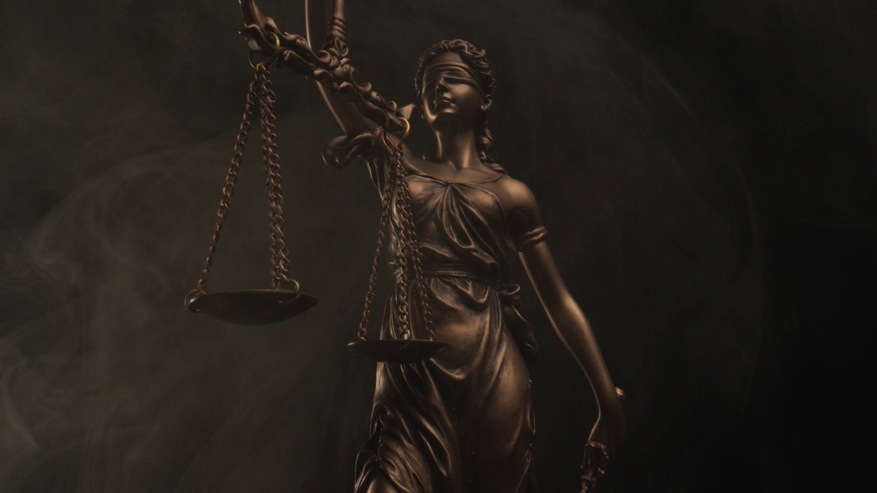 蒙眼的正义女神青铜雕像，手持衡量是非，平等和平衡的概念，黑色背景与烟雾视频下载